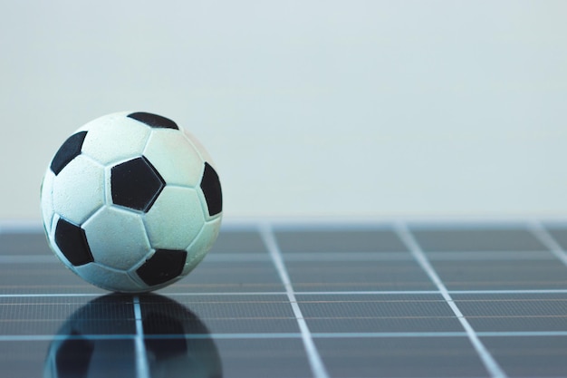 Ballon de football sur panneau solaire photovoltaïque isolé Image concept sport et technologie