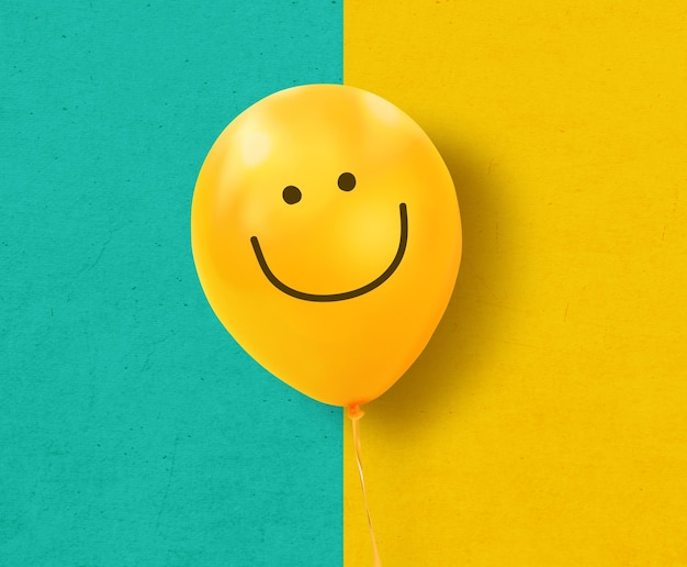 Ballon jaune avec sourire sur fond de texture bleu et jaune Concept de pensée positive