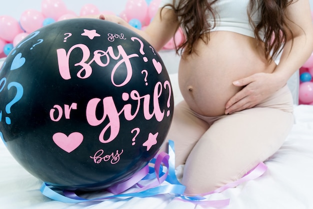 Ballon noir avec les mots fille ou garçon fête de divulgation de genre bébé fille enceinte avec ventre