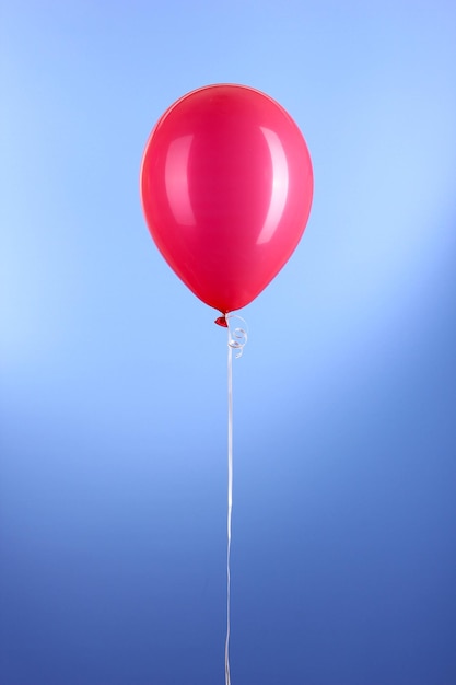 Un ballon rouge sur fond bleu