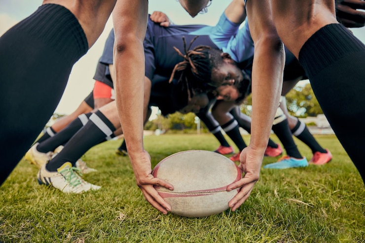 Photo ballon de rugby sportif et équipe sur le terrain hommes jouant au jeu avec énergie et forme physique en se serrant ensemble scrum de travail d'équipe et prêt pour le club de sport masculin de match professionnel et en plein air avec exercice