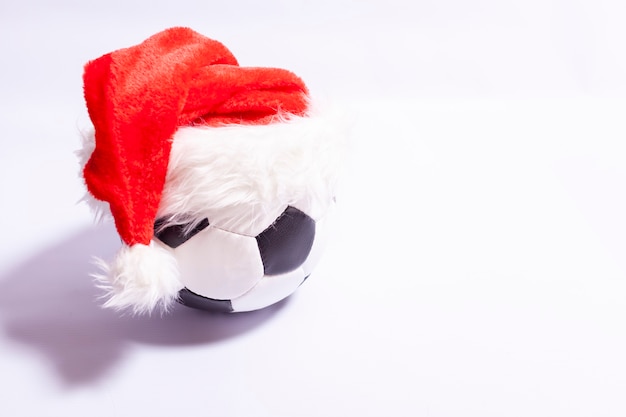 Ballon de soccer dans un chapeau de père Noël sur fond blanc