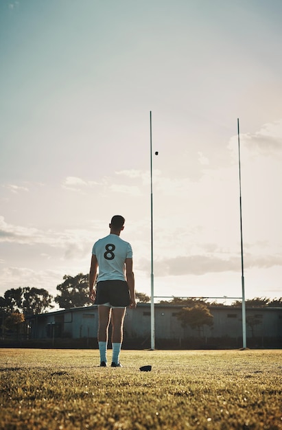 Et le ballon va vers l'arrière d'un beau jeune joueur de rugby qui s'entraîne sur le terrain durin