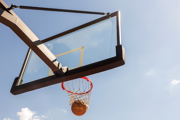 le ballon vole dans un panier de basket de rue