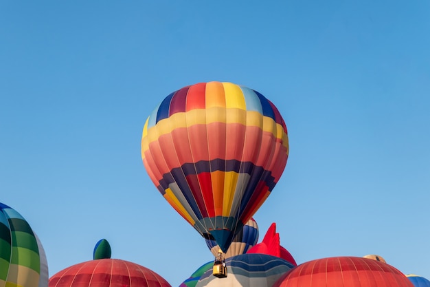 Ballons à air chaud colorés volant avec un ciel bleu au festival