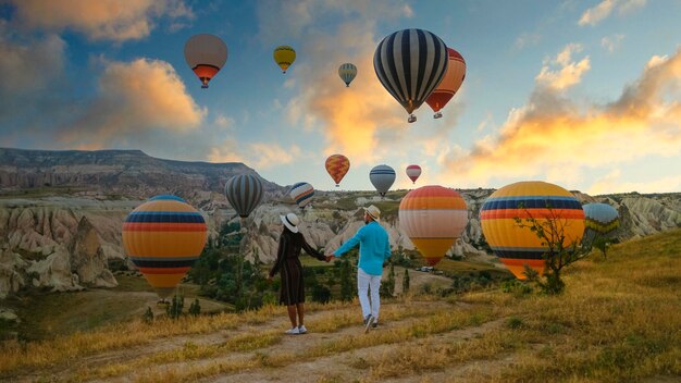 Des ballons à air chaud contre le ciel au coucher du soleil