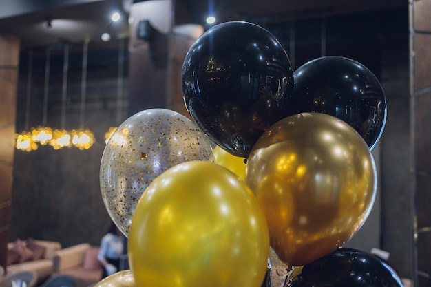 Ballons à air à l'hélium noir et or sur fond blanc célèbrent la fête