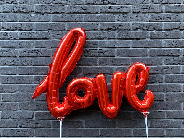 Des ballons d'amour contre un mur de briques