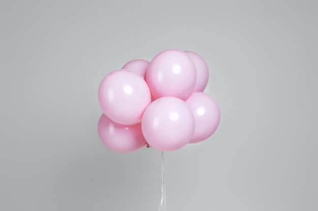 Ballons d'anniversaire rose pastel sur fond gris