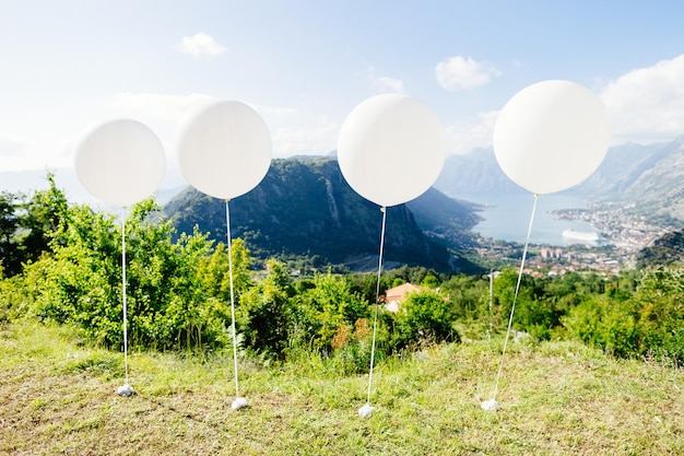 Ballons blancs volent au ciel bleu Montagnes et fond de vue sur la mer