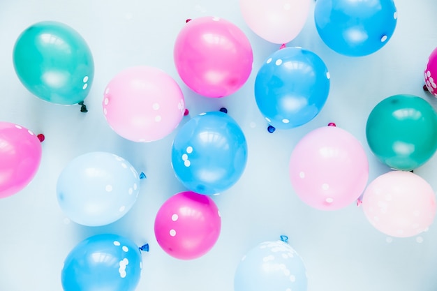 Ballons colorés sur fond bleu pastel. Concept de fête ou d'anniversaire. Mise à plat, vue de dessus.