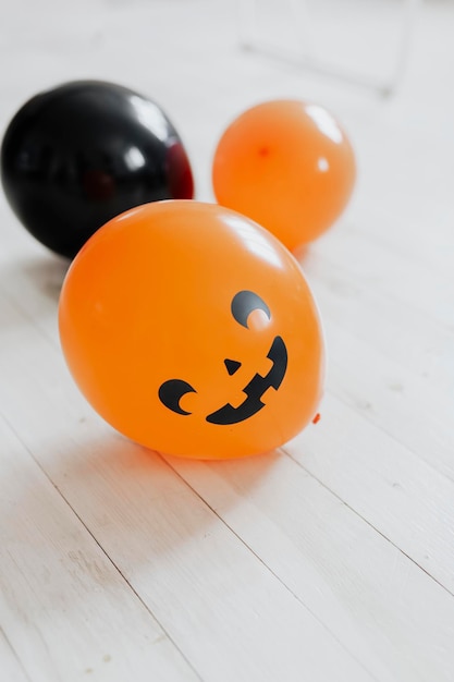 Ballons d'Halloween orange et noir sur le plancher en bois blanc