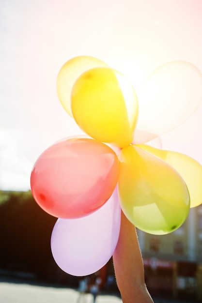 Ballons à portée de main de fille aux beaux jours