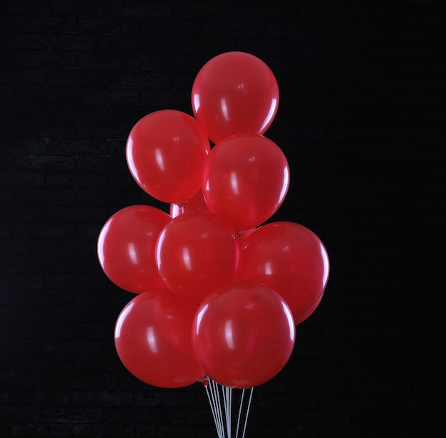 ballons rouges sur fond de mur de brique noire