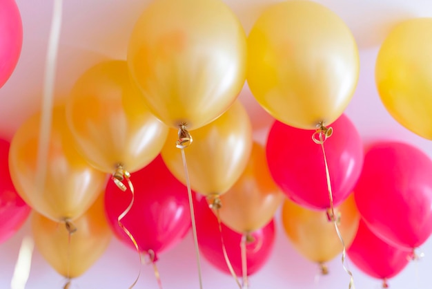 Ballons rouges et or avec de l'hélium sous le plafond pour une fête d'anniversaire