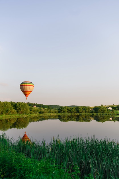 Ballooning dans la nature. Belle montgolfière survolant le lac près de l'eau.