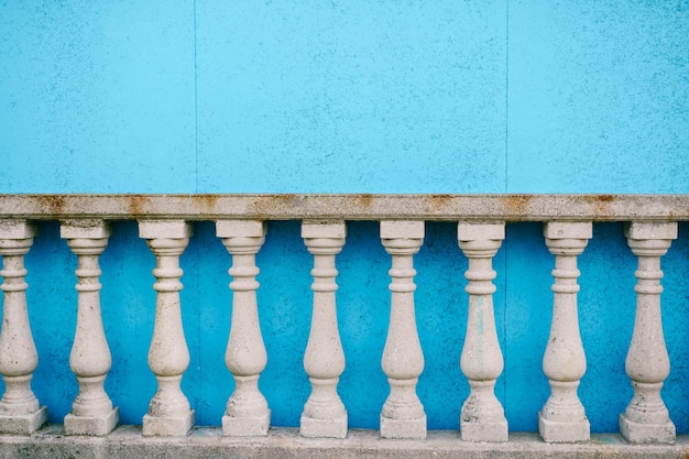 Balustrade en pierre blanche de style classique près du mur bleu