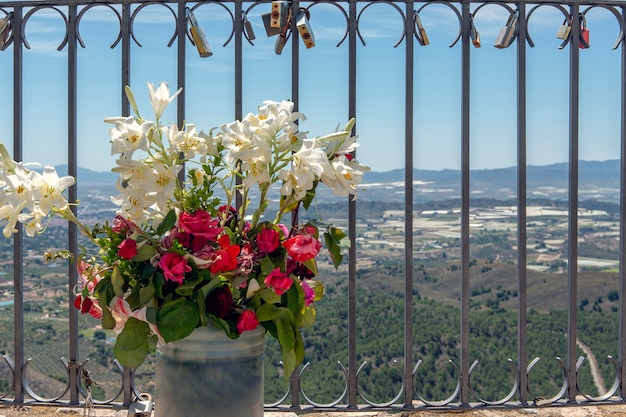 balustrade avec pot de lys lilium candidum et roses chimensis et cadenas placés par les amoureux