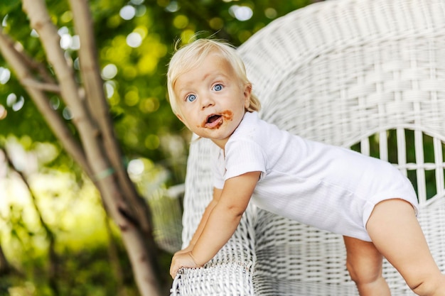 Un bambin aux yeux bleus et aux cheveux blonds avec un visage chocolat sale