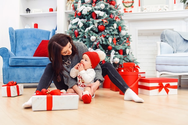 Bambin charmant avec sa mère déballant le cadeau de vacances.