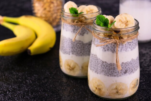 Banane Chia Pudding en pot sur fond noir Concept Snacks sains