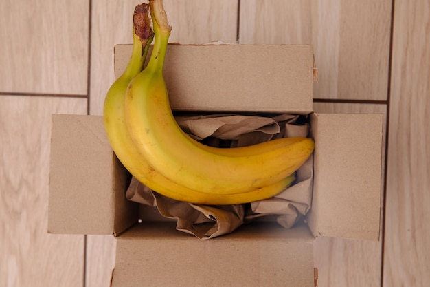 Photo banane dans une boîte en papier recyclé brun