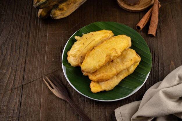 Photo banane douce et croustillante frite ou pisang goreng sur plaque blanche et feuille de banane