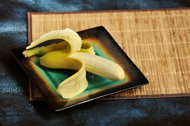 Banane à la peau coupée sur une assiette