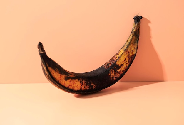 Banane pourrie isolée sur fond de couleur pop