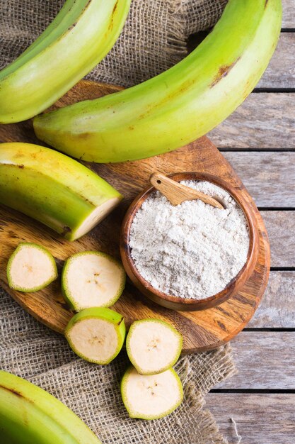 Banane verte, farine de plantains sur une table. Vue de dessus fond plat