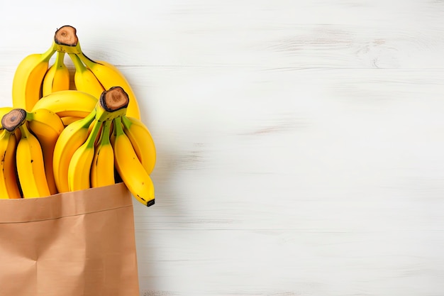 Bananes dans un sac en papier recyclé sur une table en bois blanc Vue supérieure Espace de copie