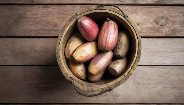 Des bananes dans un seau de bois sur un fond de bois