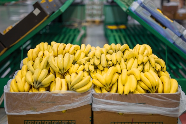 Photo bananes fraîches dans des boîtes en carton sur un grand super marché
