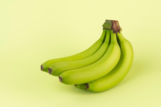 Bananes fraîches vertes sur fond vert