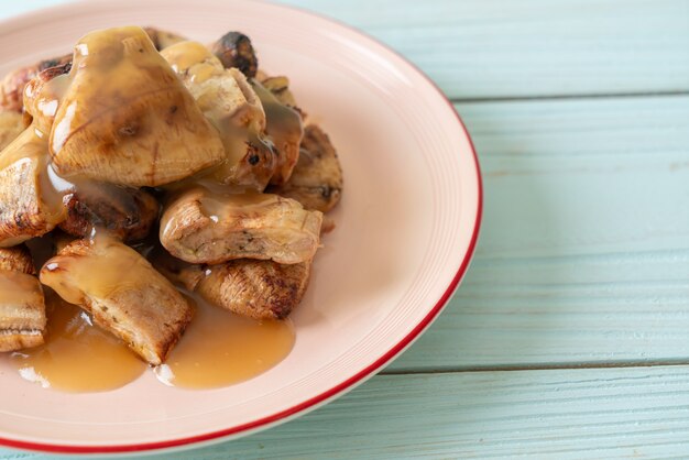 Bananes grillées avec sauce caramel à la noix de coco sur assiette