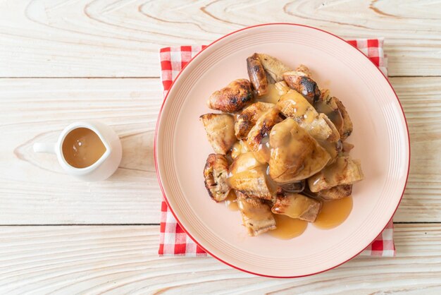 Bananes grillées avec sauce caramel à la noix de coco sur assiette