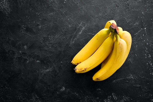 Bananes jaunes fraîches sur une table en pierre noire Vue de dessus Espace de copie gratuit