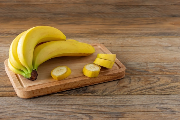 Bananes mûres sur fond de bois. Savoureux fruits tropicaux sains.