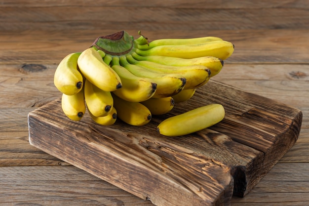Bananes mûres sur fond de bois. Savoureux fruits tropicaux sains.