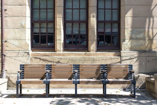 Banc en bois à côté du passage couvert en pierre devant le vieux bâtiment avec l'architecture décorative