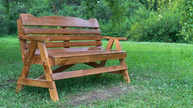 Banc en bois dans le parc sur l'herbe