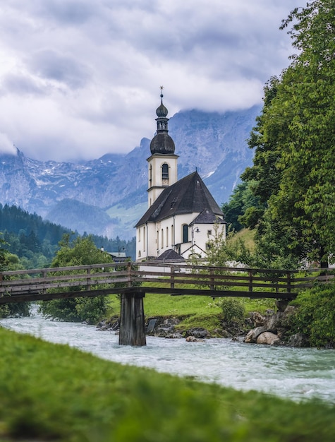 Un banc en bois avec église paroissiale rivière abd montagnes en arrière-plan Berchtesgaden Ramsau Allemagne