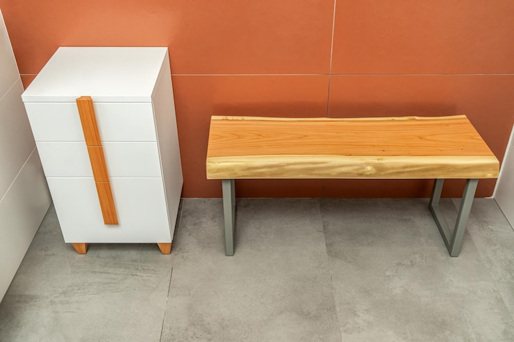 Photo banc en bois avec des jambes en métal et armoire blanche avec des poignées et des jambes en bois dans la salle de bain