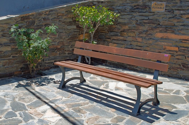 Banc en bois avec mur en pierre noire