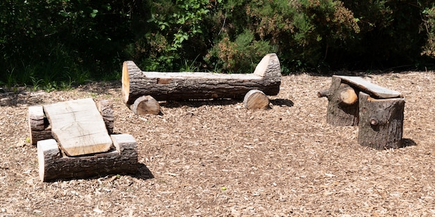 Banc en bois naturel fait maison rustique en tronc d'arbre dans le parc trois