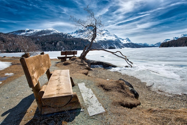 Banc en bois pour admirer le paysage sur un lac de glace alpin