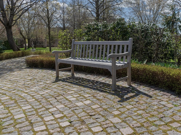 Un banc en bois se repose sur un passage couvert de brique en parc