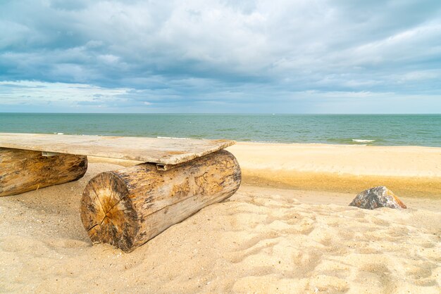 banc en bois vide sur la plage avec fond de plage de la mer