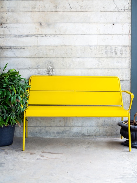 Banc jaune moderne sur fond de mur en béton