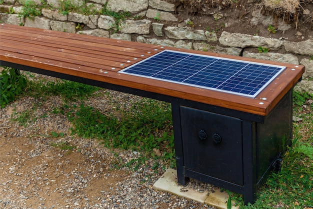 Un banc moderne pour charger des téléphones et des tablettes sur le fond du mur de briques.